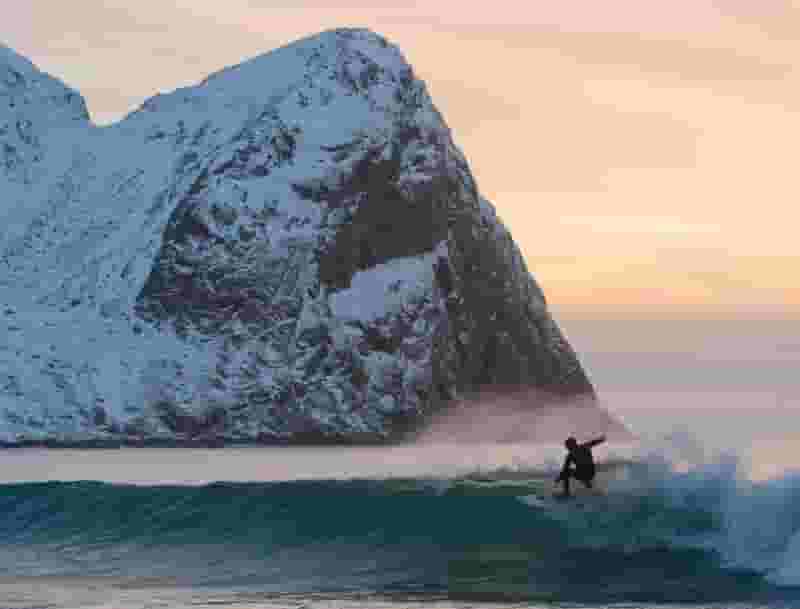 surfing next to snowy mountain