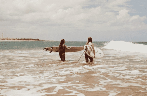 surfers heading into water