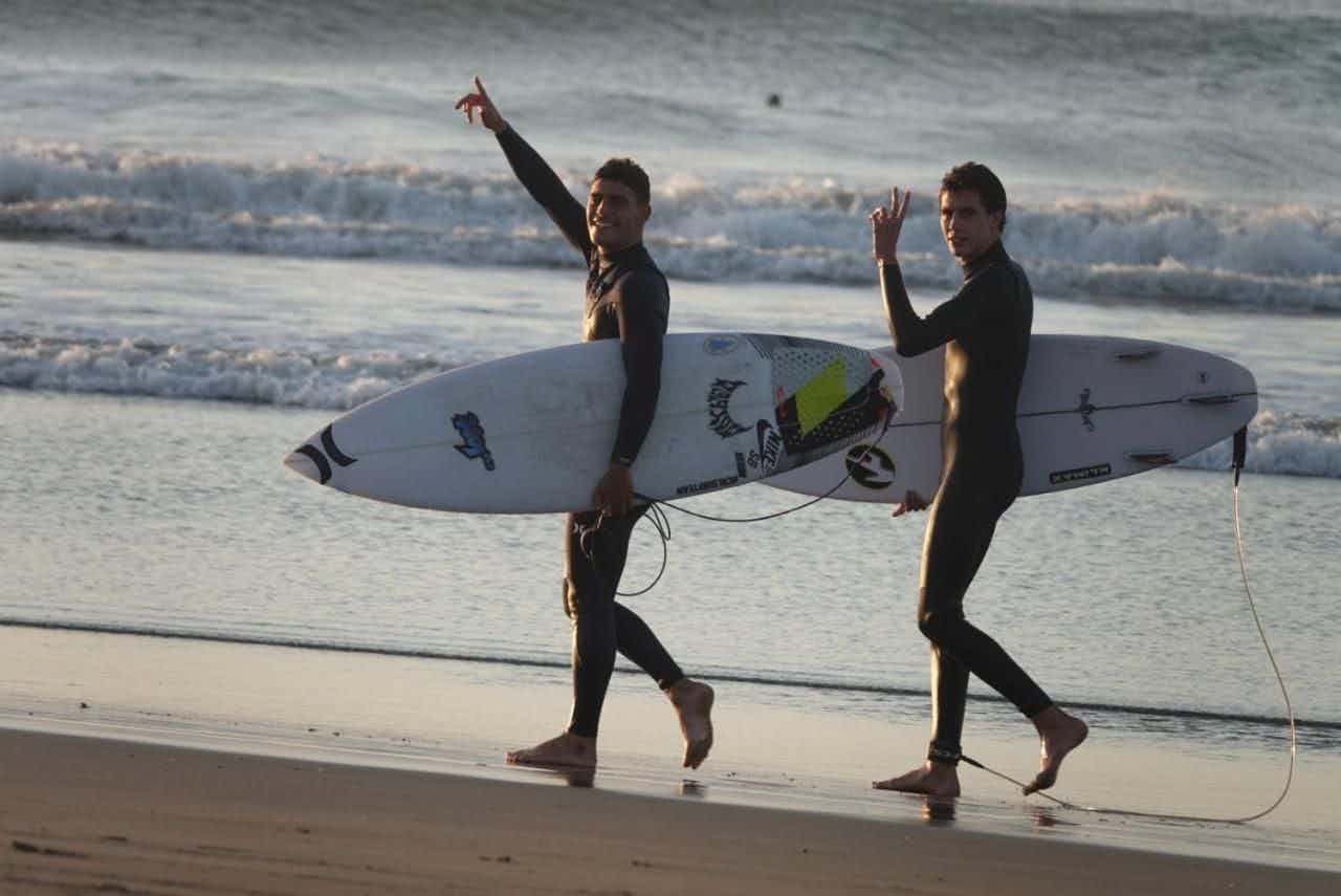 surfers on the beach in Lobitos