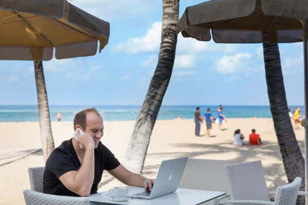 digital nomad working from beach