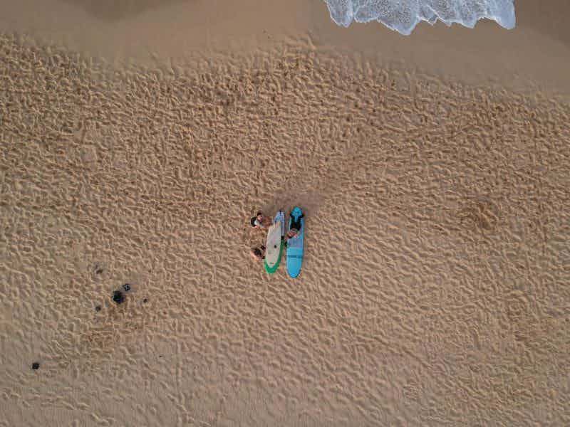 drone shot of surfers on beach