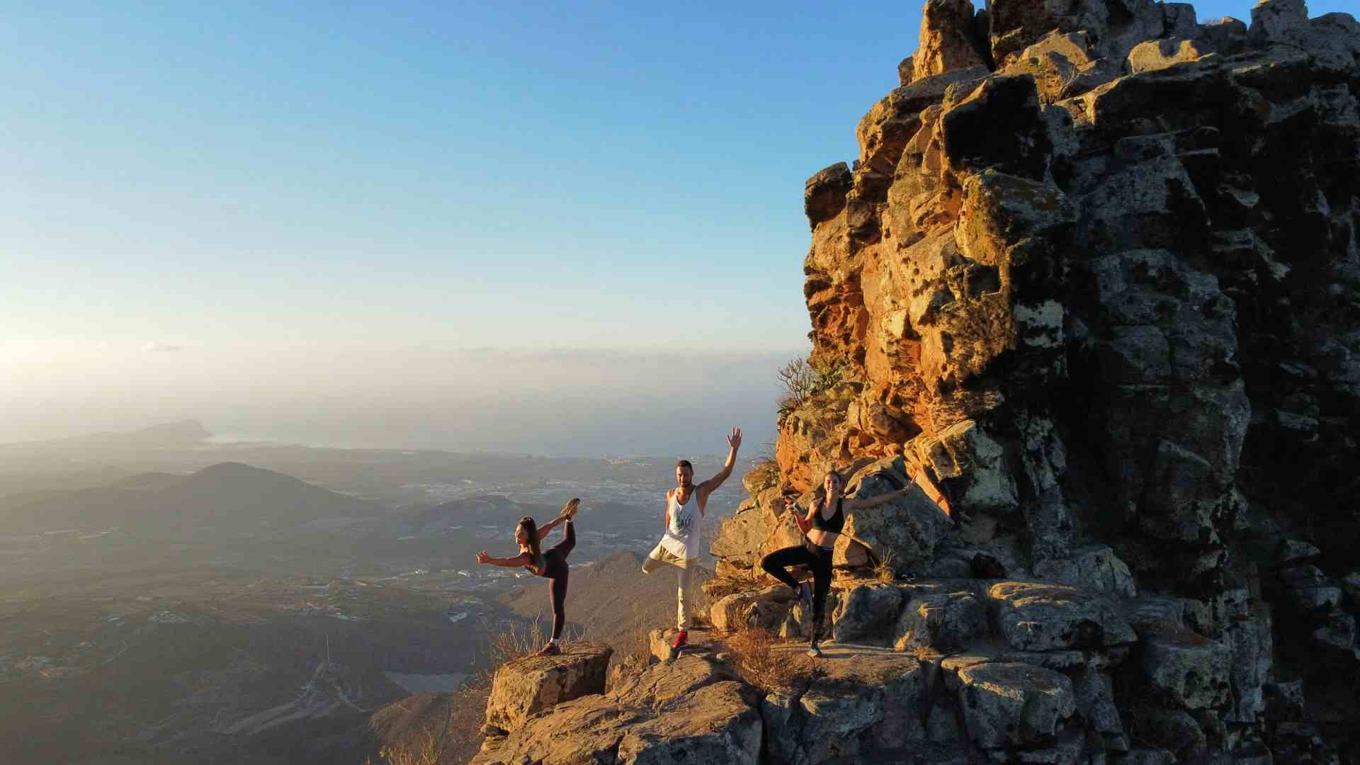 yoga on a rock high above